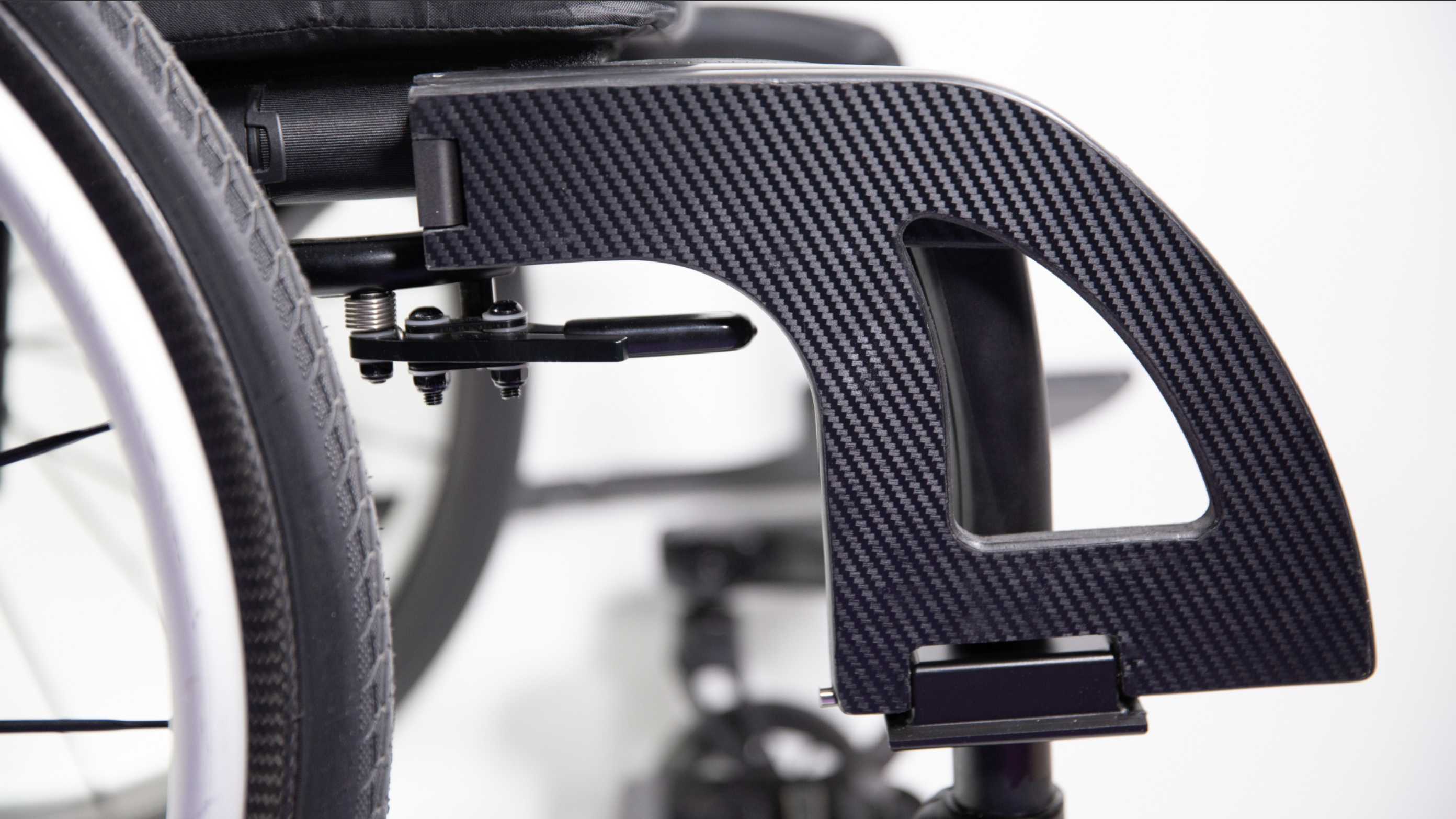 The Auxilia device in collapsed form on the leg of the wheelchair